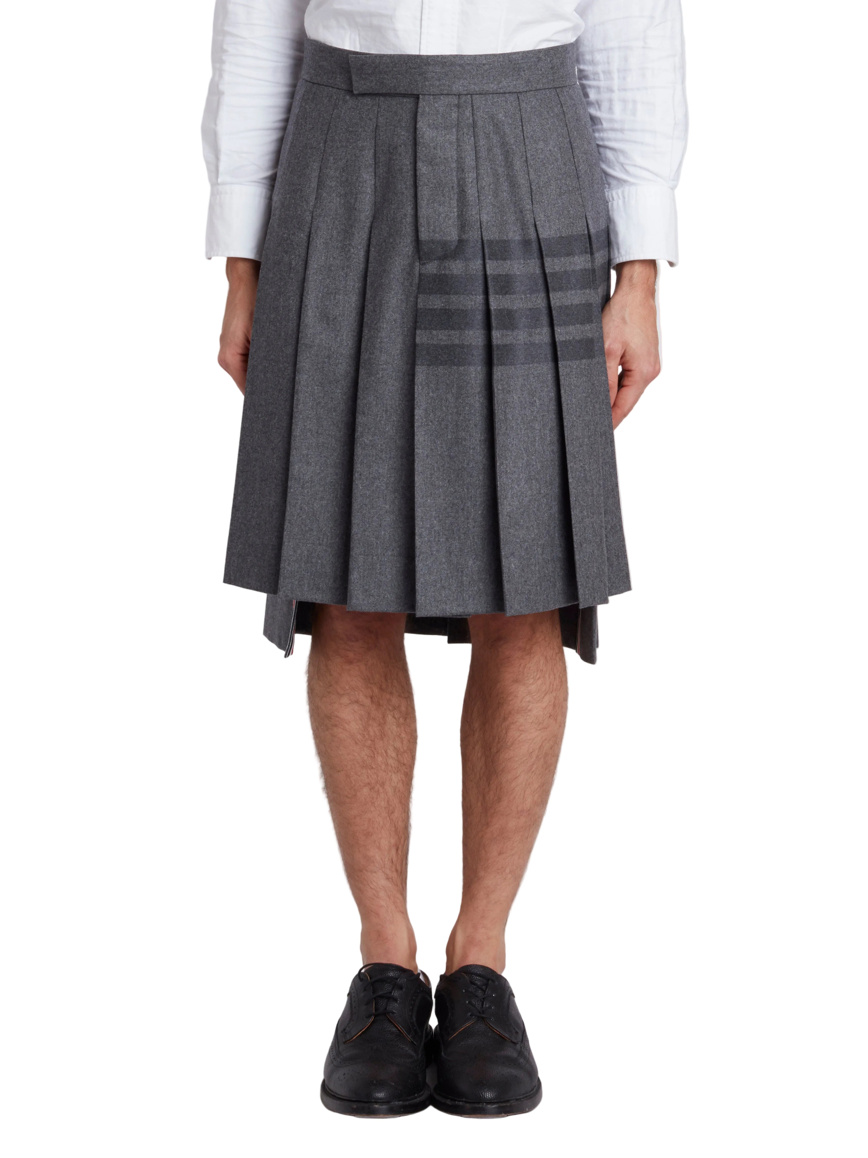 Klassisk knälång plisserad kjol med axelband och midja i ton-i-ton flanell med fyra stycken detaljer